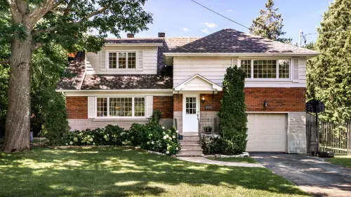 Two-story brick and siding home with mature landscaping